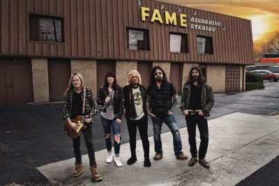 Die Hardrockband The Dead Daises steht vor einem Aufnahmestudio.