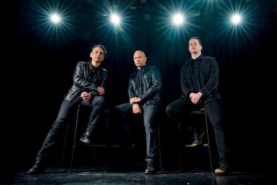 Die drei Mitglieder der Rockband Danko Jones sitzen auf Barhockern